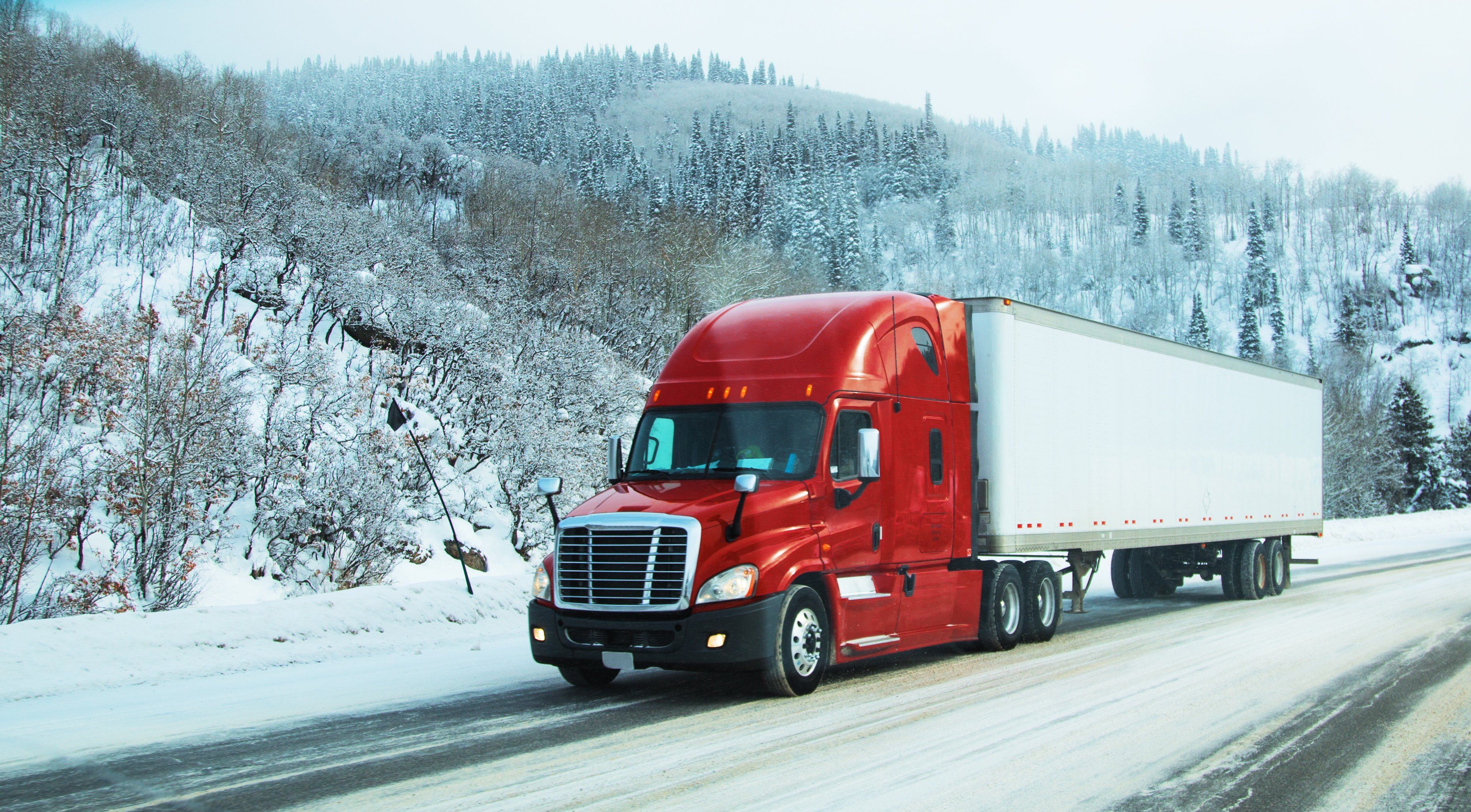 A semi truck driving on a winter road