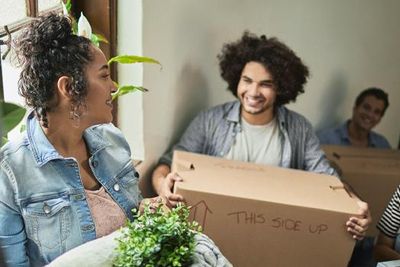 College students carry moving boxes.
