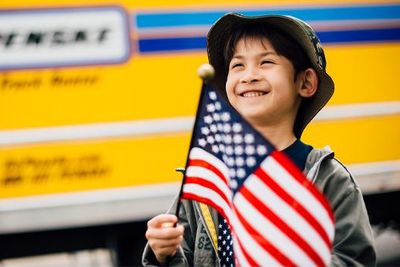 Boy holding American flag in front of a Penske truck.