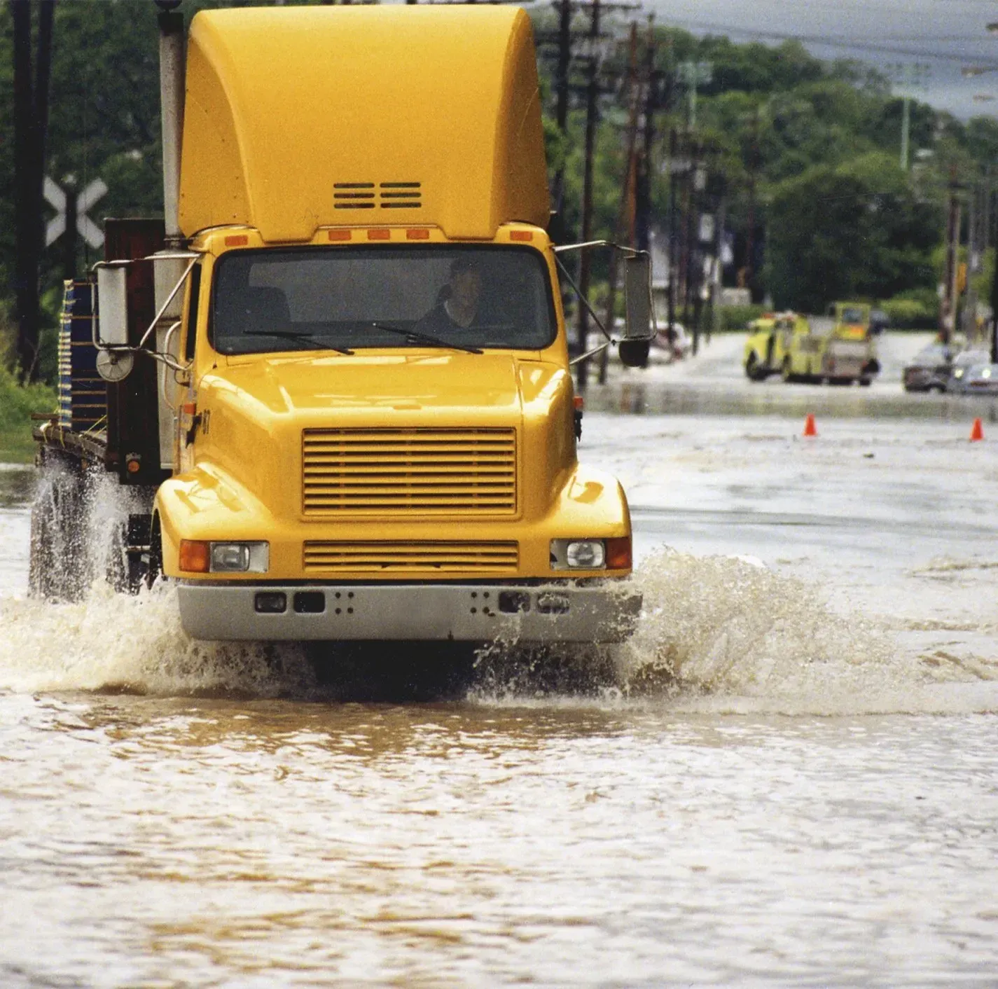 A semi-truck drivers through standing water